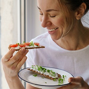 Closeup of woman smiling while eating healthy snacks