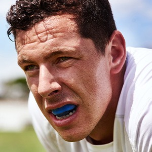 Closeup of man wearing blue mouthguard