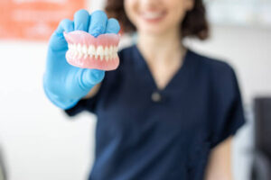 Lab technician holding a set of dentures