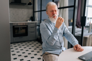 Man eating with dentures in his kitchen